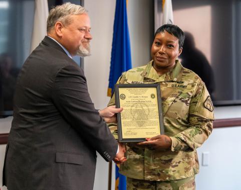 PM DIBS Mr. Kevin Curry passes the charter for Army Contract Writing System (ACWS) to new product lead, Lt. Col. Camille Morgan at a ceremony held July 19, 2024.