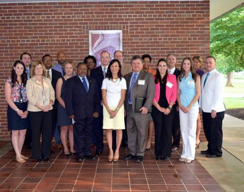 CHESS Industry Day attendees stand for photo in front of brick wall.