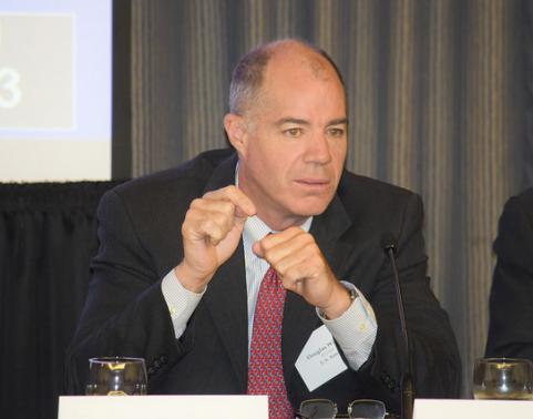 Mr. Douglas Wiltsie sits at panel table and gestures while speaking.