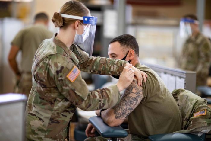 Army medic immunizing Soldier