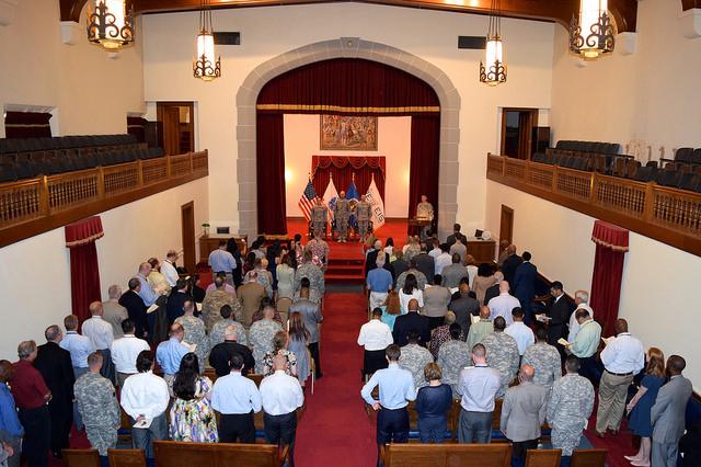 Aerial shot of crowd standing in front of chairs in auditorium. 