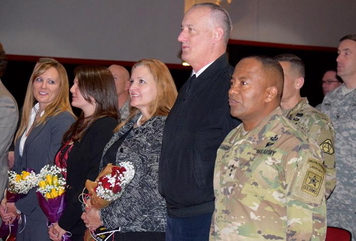 People smiling in crowd at ceremony.