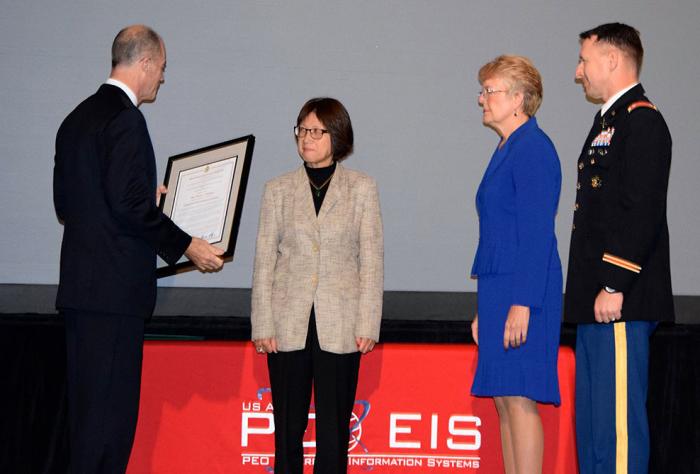 Man presents woman with a framed certificate.